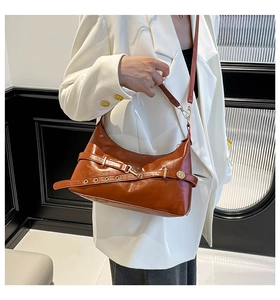 Détail du sac bandoulière en cuir caramel avec boucle métallique et texture fine