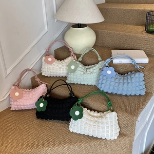 Sacs à bandoulière minimalistes à texture pop-corn en plusieurs couleurs sur escalier