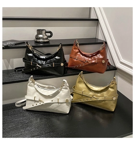 Detailed view of four glossy leather tote bags in black, brown, white and gold colors