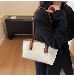 Detail of the chic knot design on cream and brown leather tote with gold hardware