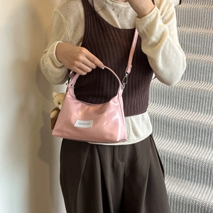 Pink glossy denim-style dumpling bag with plush bear charm and metallic zipper