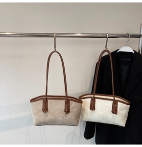 Detail showing two minimalist suede tote bags in light brown and cream with knot handles