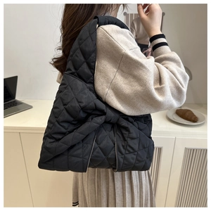 Fashionable black quilted bow shoulder bag shown on model in a minimalist lifestyle setting
