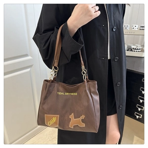Detail of brown leather tote bag with Tidal Dryness print and chain shoulder strap