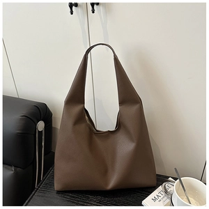 Close-up of dark brown lychee leather texture on a stylish commuter tote bag