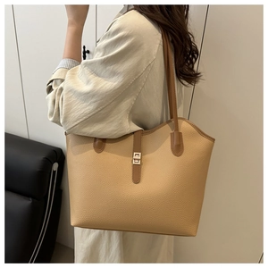 Detail of beige lychee pattern tote bag with metal square buckle and dark brown strap
