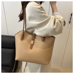 Detail of lychee pattern leather tote bag with gold metallic buckle and brown strap