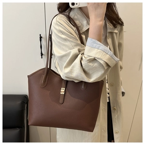Close-up of brown litchi pattern leather tote bag with elegant gold square buckle detail