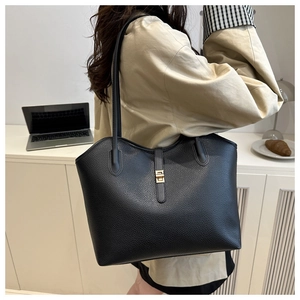 Detailed view of black lychee grain leather tote bag with elegant gold metal twist lock