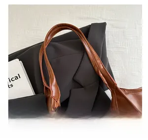 Close-up of the vintage brown faux leather tote bag handle with refined sewing details