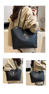 Detail of black litchi pattern leather tote bag with gold metal twist lock and shoulder strap