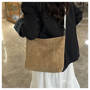 Détail du sac cabas en velours côtelé marron et du crochet métallique de la bandoulière