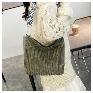 Gros plan du sac fourre-tout en velours côtelé vert avec bandoulière à motifs géométriques