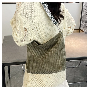 Détail d'un sac fourre-tout en velours côtelé vert foncé avec large bandoulière tissée