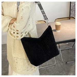 Détail du sac cabas en velours côtelé noir avec large bandoulière à motifs géométriques