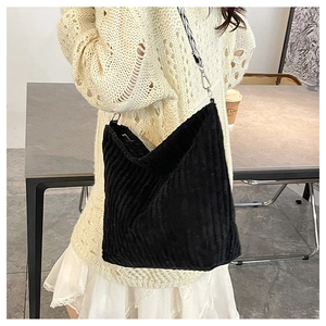 Détail du sac fourre-tout en velours côtelé noir avec bandoulière tissée sur un modèle