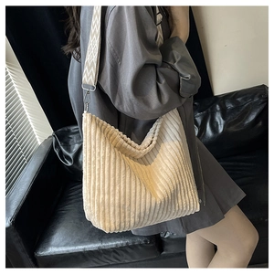 Détail d'un sac cabas en velours côtelé crème avec texture et bandoulière large jacquard
