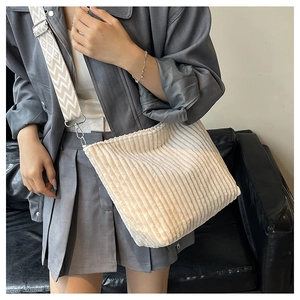 Détail du sac fourre-tout en velours côtelé crème avec une large bandoulière géométrique