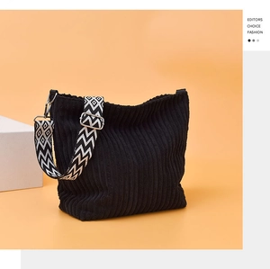 Détail d'un sac cabas en velours côtelé noir avec texture et sangle géométrique
