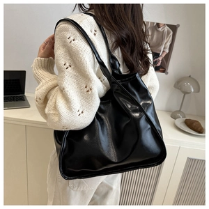 Black large-capacity PU leather tote bag shown in a minimalist office setting