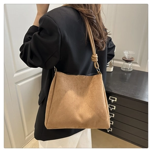 Détail du cabas vintage en daim marron avec un design de bandoulière nouée minimaliste