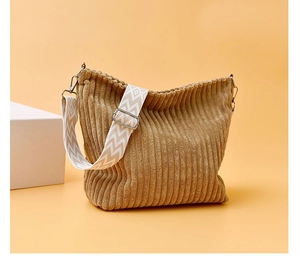 Détail du sac en velours côtelé kaki avec texture rayée et large bandoulière à motifs