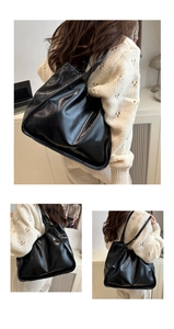 Detail view of large black shiny PU leather tote bag with long shoulder straps for daily commute