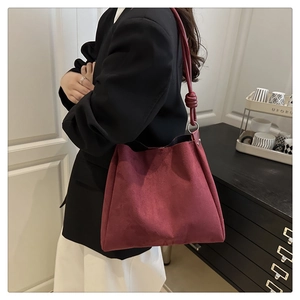 Sac seau vintage en daim bordeaux avec bandoulière nouée et anneaux métalliques chic