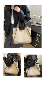 Detail shot of large canvas tote bag with brown trim showing shoulder carry and side profile