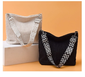Détail de sacs cabas en velours côtelé avec larges bandoulières et attaches métalliques