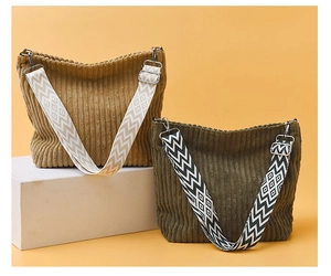 Détail de sacs hobo en velours côtelé marron et vert avec larges bandoulières à motifs