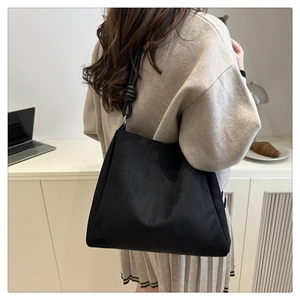 Détail du sac cabas en daim noir avec bandoulière nouée et finition en cuir mat