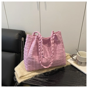 Close-up of pink mesh tote bag featuring woven rope handles and textured fabric detail