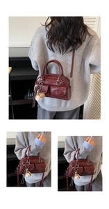 Detail view of burgundy leather Boston bag with double pockets and baseball keychain