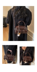 Detail of dark brown glossy leather Boston bag with decorative pockets and baseball charm
