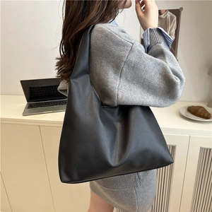 Minimalist black pebbled leather tote bag with wide strap for casual daily commuting