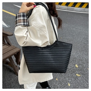 Detail of black woven pattern tote bag showing high-capacity design and shoulder strap texture