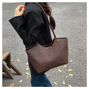 Detail of woven texture and dark brown leather on this large minimalist tote bag