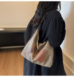 Detail view of large vintage canvas shoulder bag with leather patches on model's back