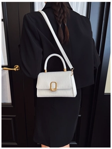 Vue arrière d'un petit sac carré blanc avec motif crocodile et boucle dorée sur un blazer