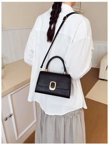 Vue portée montrant la taille du petit sac bandoulière noir avec motif crocodile