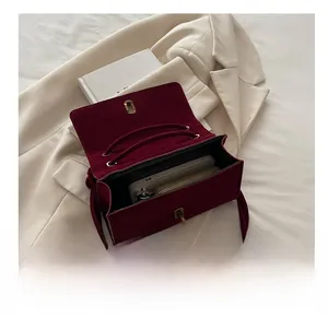 Detail showing the inner capacity of this burgundy velvet shoulder bag with flap