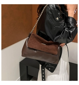 Detail of dark brown chain bag showing suede and smooth leather textures on a model