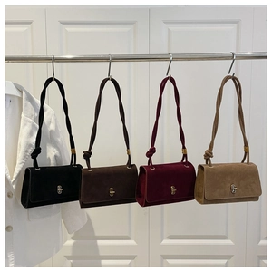 Row of four suede crossbody bags with golden locks in black, brown, red, and khaki