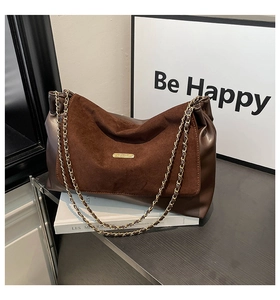 Detail of dark brown chain bag with mixed suede and leather textures on a modern background