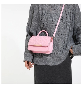 Primer plano del bolso rosa de cuero sintético acolchado con costuras onduladas y oro