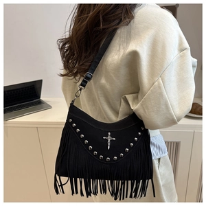 Sac bandoulière noir à franges avec clous argentés et croix vintage porté par le mannequin