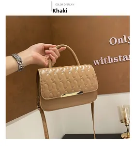 Dettaglio borsa trapuntata kaki con cuciture ondulate e fibbia in metallo dorato