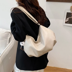 Chic off-white leather hobo bag with plush charm, minimalist large shoulder tote for women