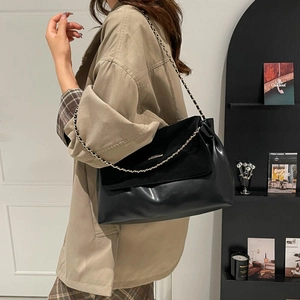 Retro black leather tote bag with chain strap shown on a model for a modern minimalist style